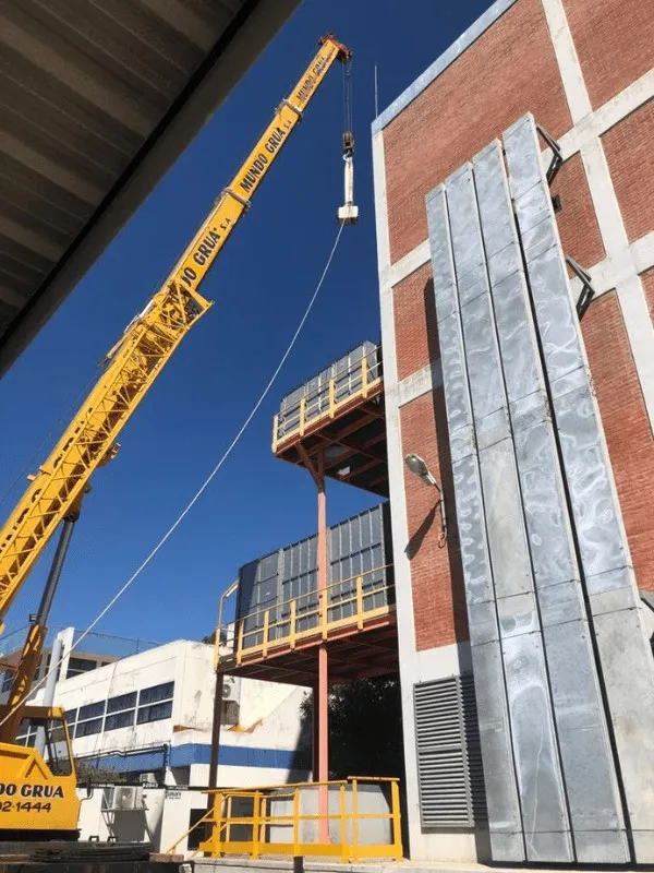 Grúa montando un shelter de energía en una planta industrial